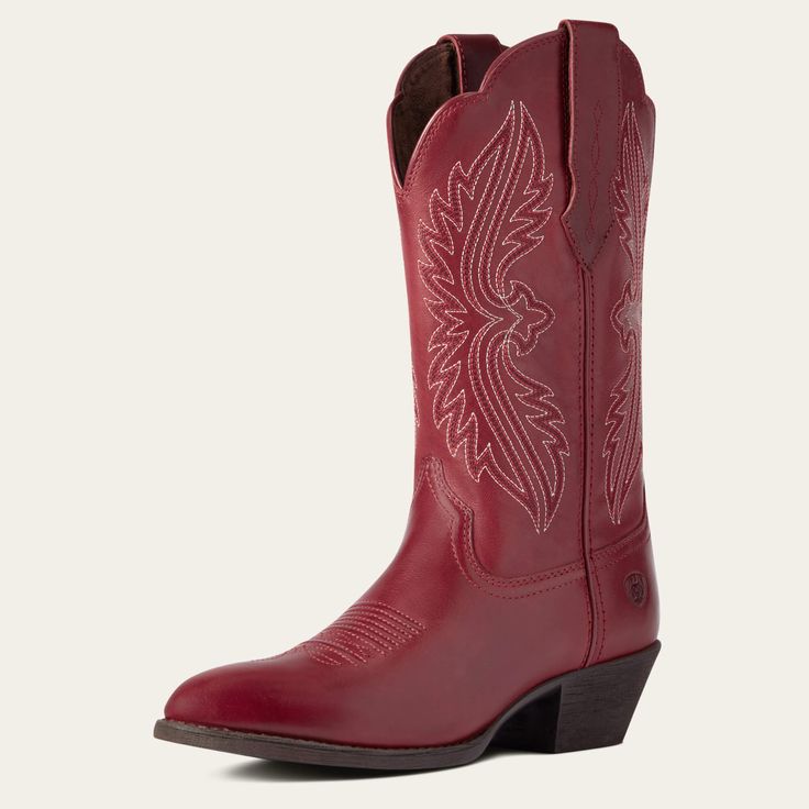 a pair of red cowboy boots with white embroidered design on the side and black soles