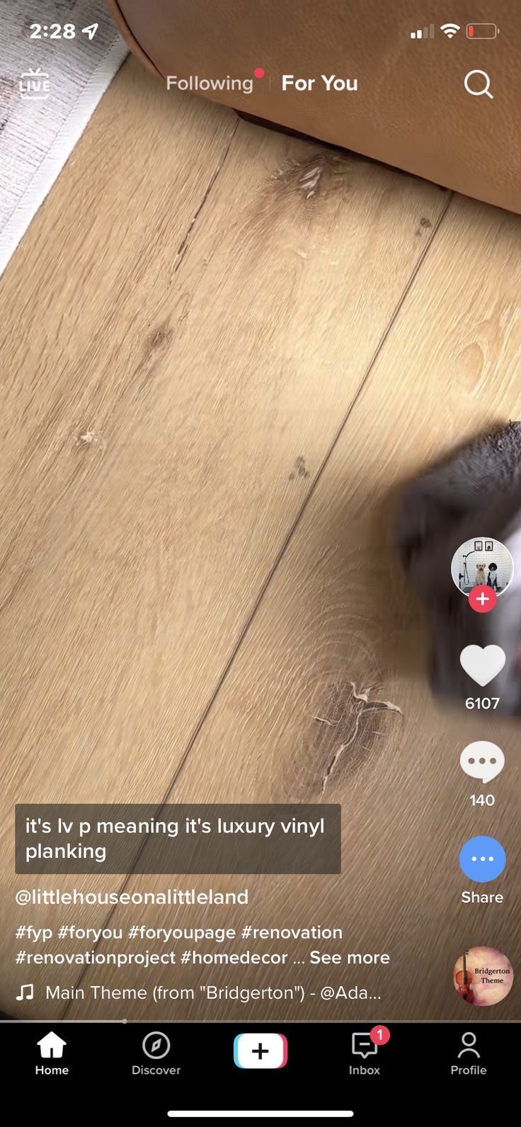 the cat is sitting on the floor and looking at the phone screen that's connected to it