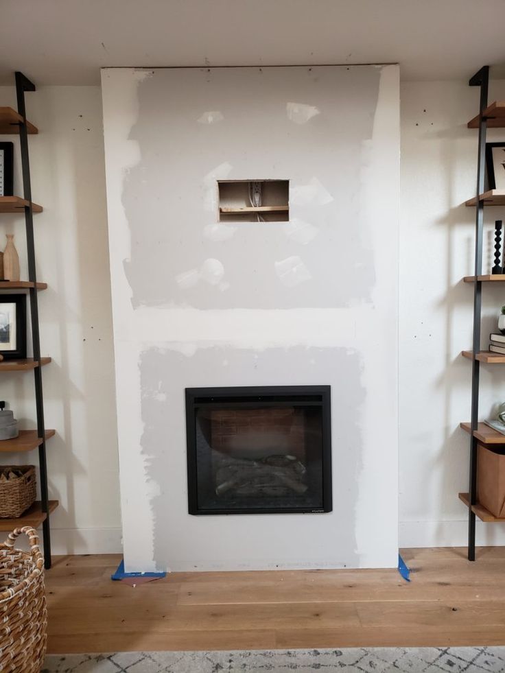 a living room with a fire place and shelving in the wall next to it