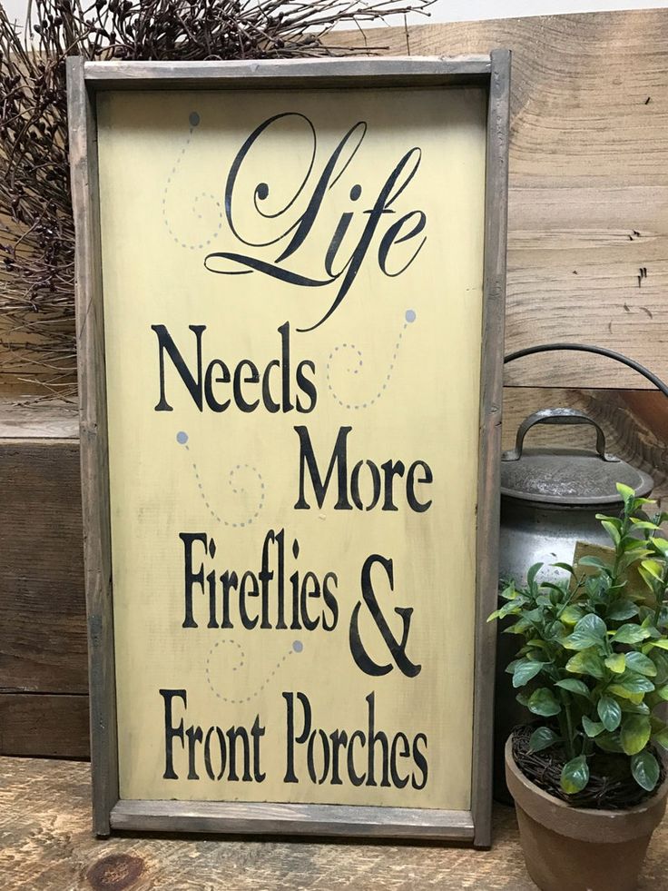 a sign that says life needs more fireflies and front porches on it next to a potted plant