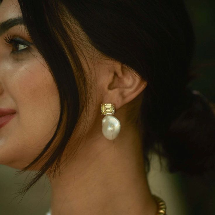 a close up of a person wearing some kind of earring with pearls on it