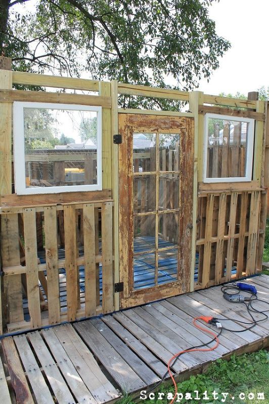 a house made out of wooden pallets and windows