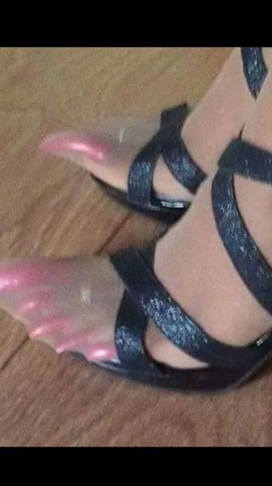 a woman's feet wearing black sandals with pink heeling and straps on the toes