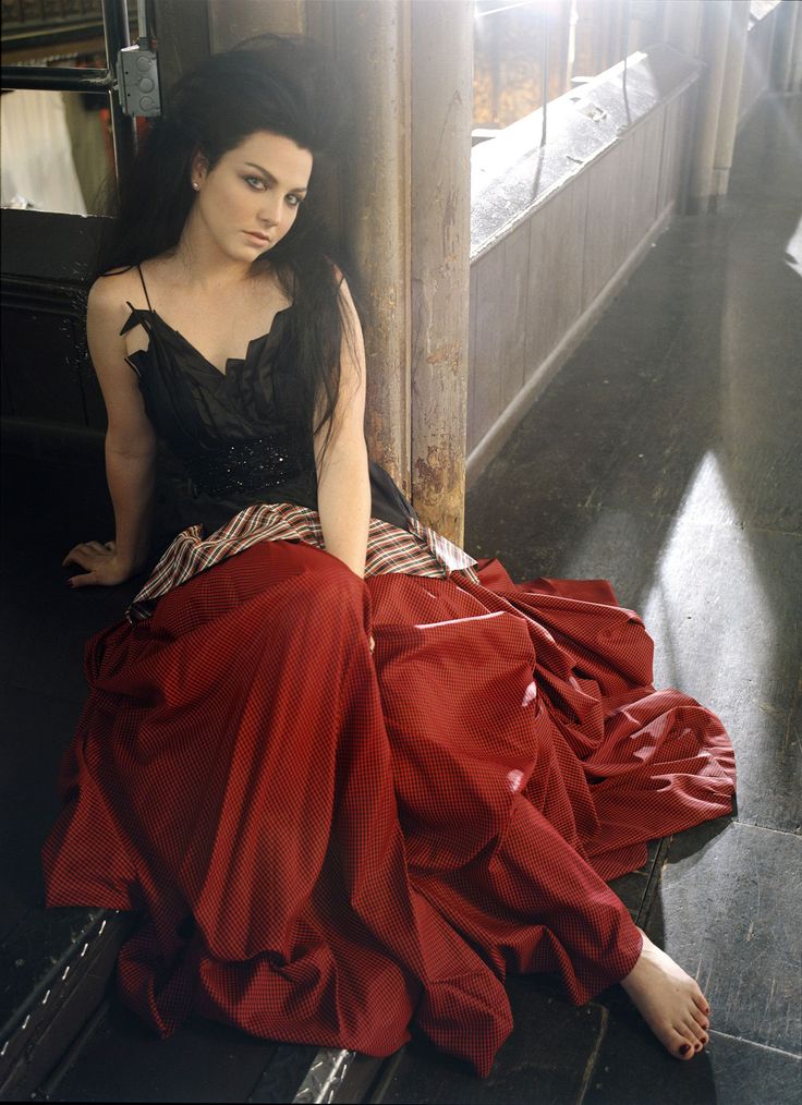 a woman in a red dress sitting on the ground