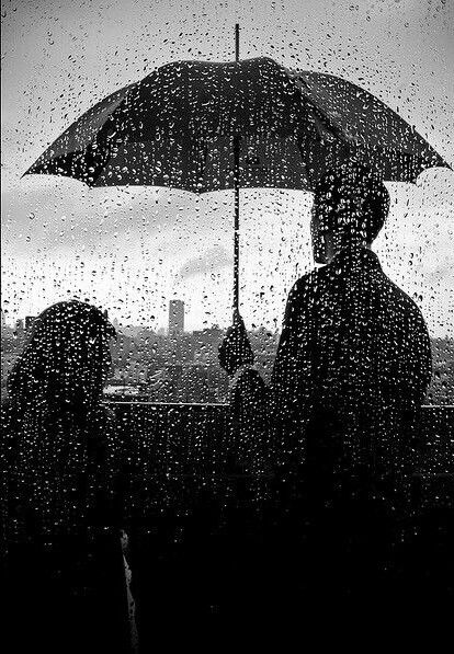 two people standing under an umbrella in the rain