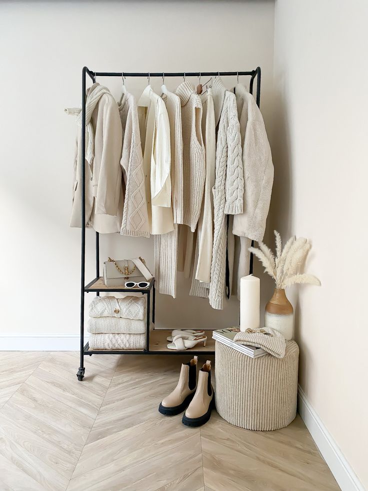 a clothing rack with shoes and sweaters hanging from it's sides in a room