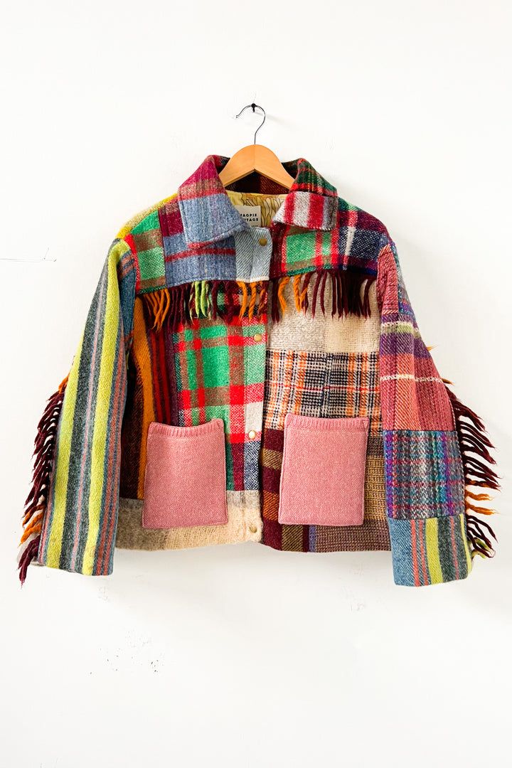 a multicolored jacket hanging on a wooden hanger