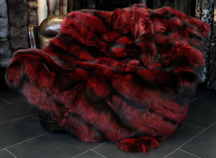 a large red fur rug sitting on top of a chair