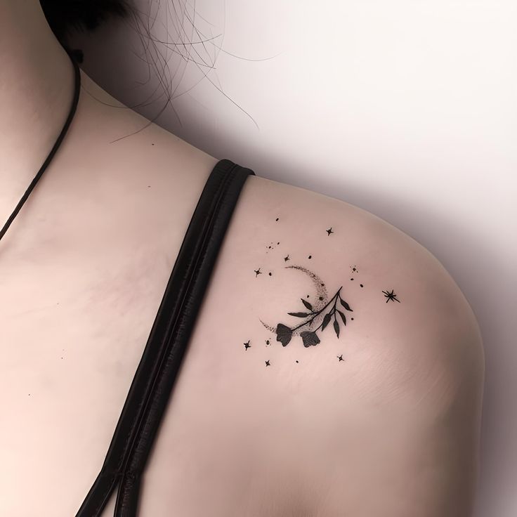 the back of a woman's shoulder with an arrow and stars tattoo on it