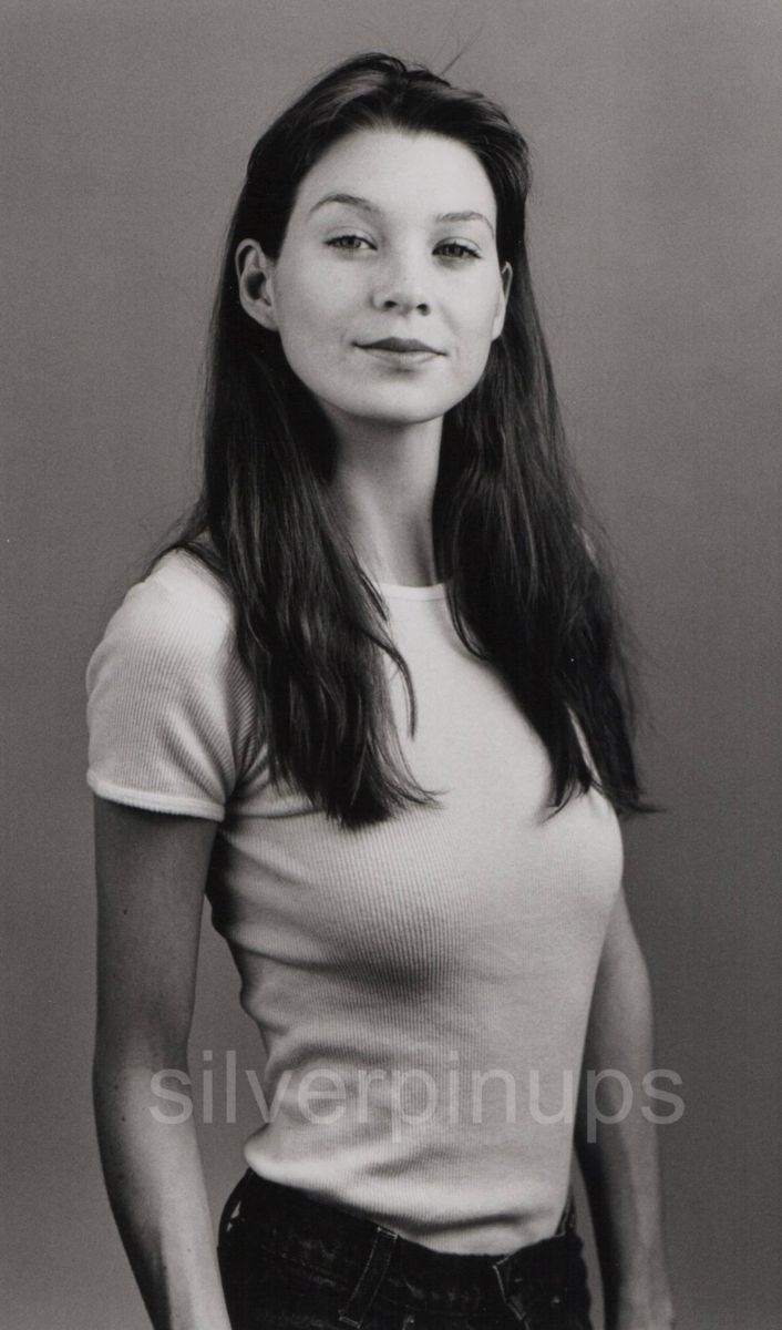 an old black and white photo of a woman with long hair wearing a t - shirt