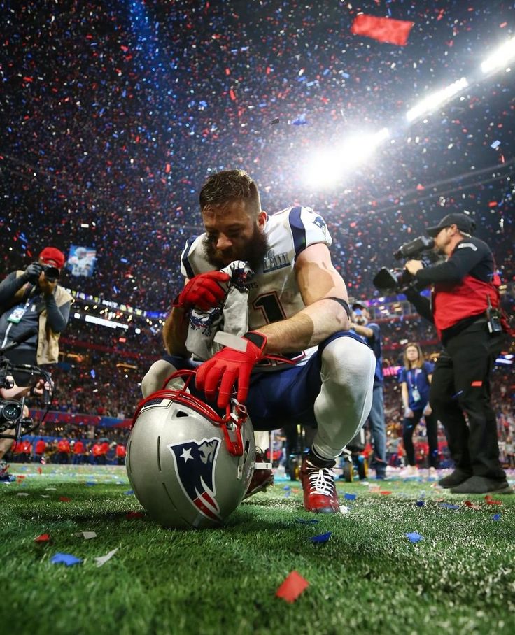 a football player kneels on the field as confetti falls in the air