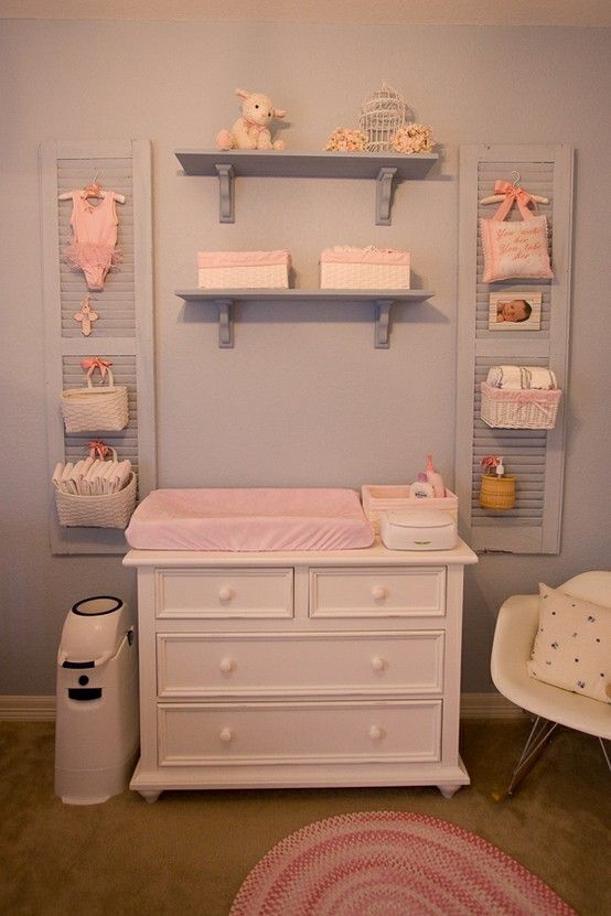 a baby's room with blue walls and white furniture