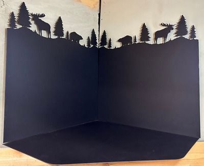 an open book with paper cut out of it and animals in the woods on top