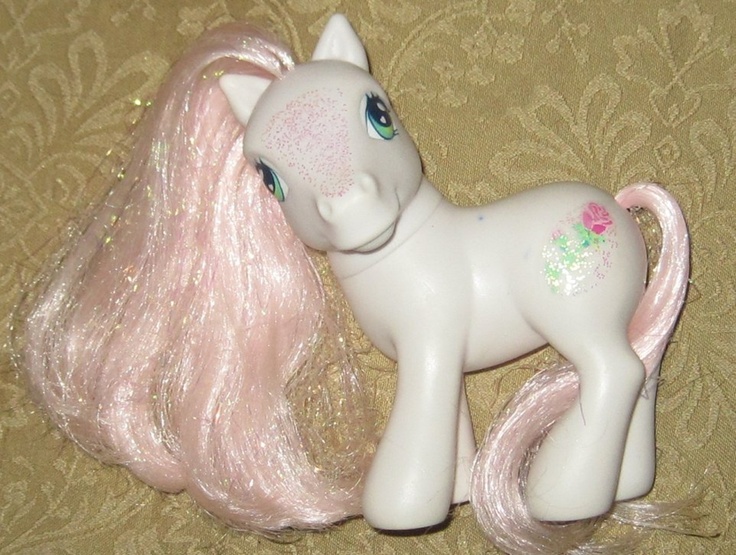 there is a toy pony with pink hair on the bed