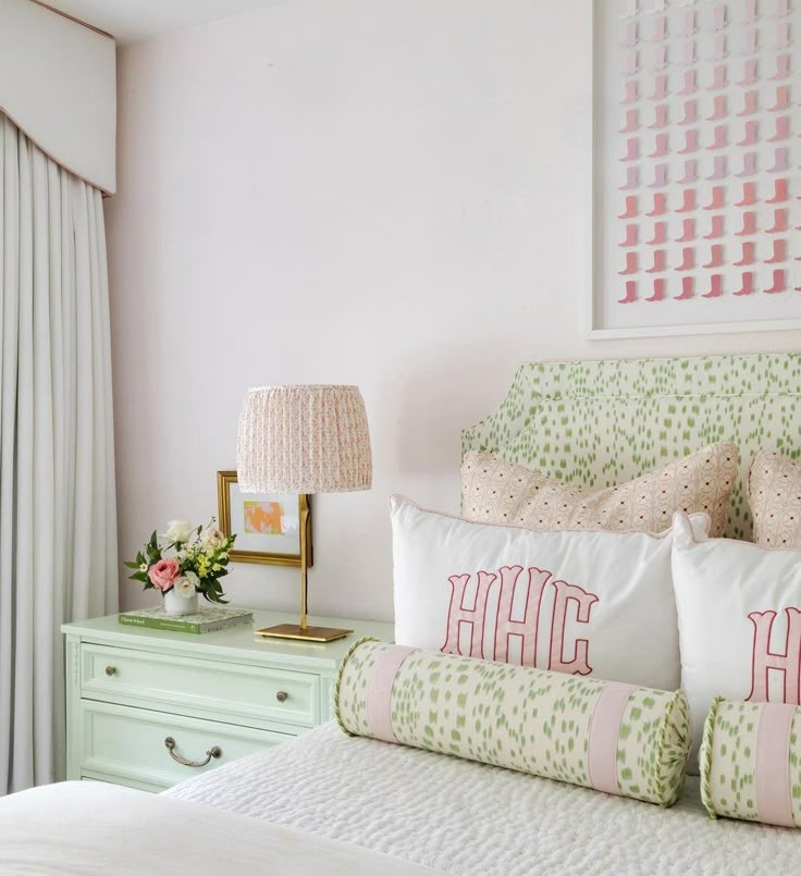 a bedroom with pink walls and white bedding