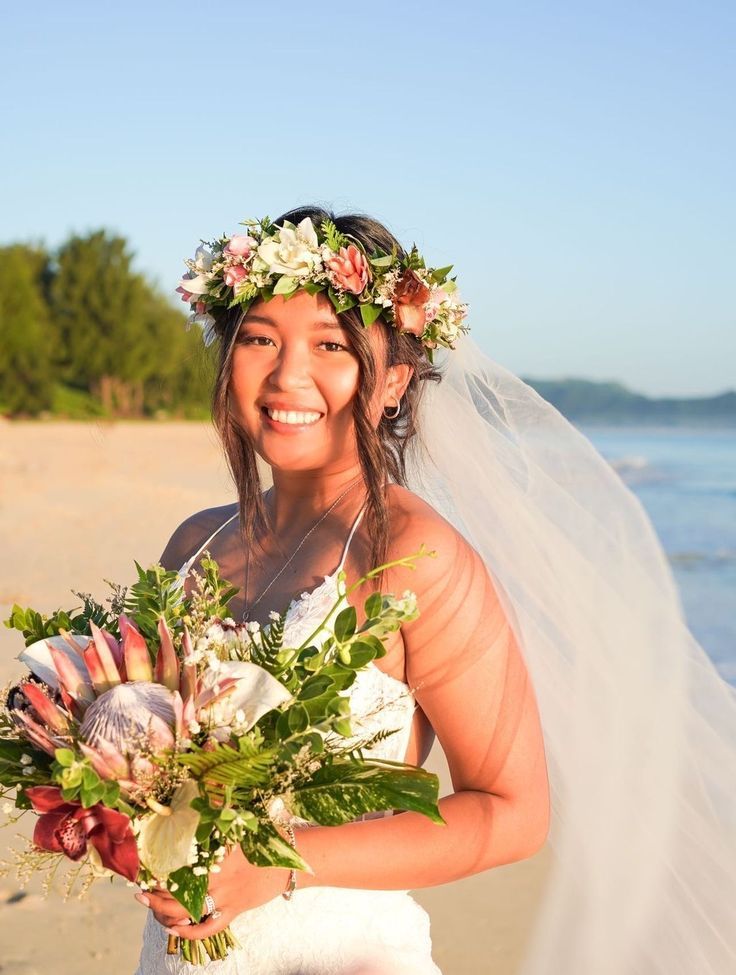 a bride on the beach with her bouquet