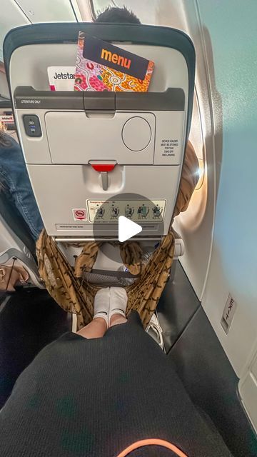 someone is sitting on an airplane with their feet up