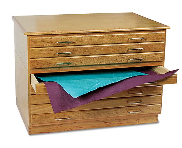 a wooden file cabinet with blue paper on top