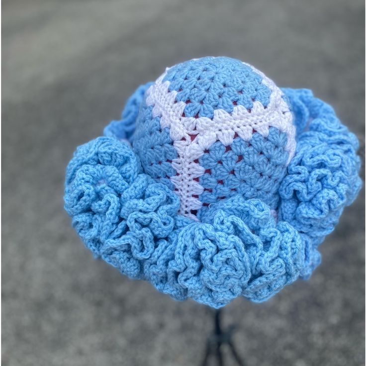 a blue crocheted hat with a white cross on it