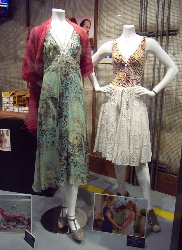 two mannequins dressed in dresses and shoes on display at a store window