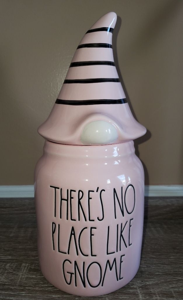 there's no place like gnome ceramic jar with black and white stripes on it