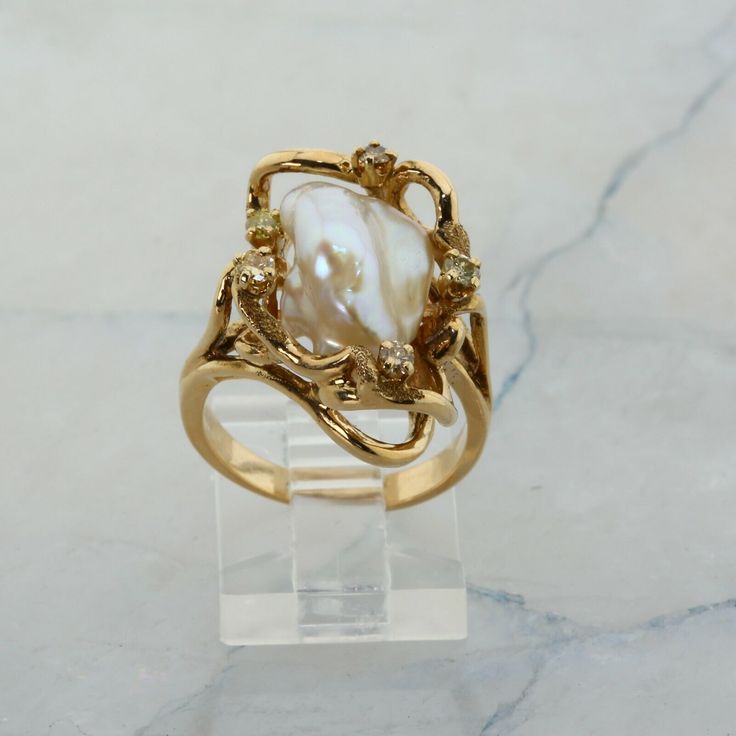 14K Yellow Gold Pearl and Diamond Ring, interesting asymmetrical design, Ring size 6.5, 8.7 grams Stock # R00070 This listing contains photographs of the actual item you will receive.  Our items are in excellent condition with little or no signs of wear and many are one of a kind pre-owned estate finds.   Please look closely at the pictures in this listing as they are part of the product description. Please read the description, as any imperfections or condition comments will be included.  We do our best to accurately describe the condition of each piece and encourage you to ask questions prior to purchase.    We are happy to address any questions you may have.  Please contact us.  Our Store has many other items for sale.  We specialize in fine & designer jewelry, watches & more.    Coloni Vintage Engagement Rings Not Diamond, Connected Engagement And Wedding Ring, Art Deco Pearl Ring, Opal Ring Stack, Gold Engagement Ring With Silver Band, Long Diamond Ring, Taurus Engagement Ring, Gold Engagement Ring With Pearl, Wedding Rings With Opal