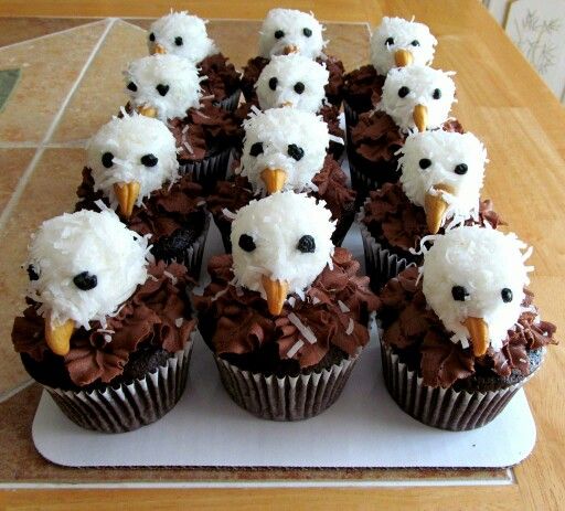 cupcakes with white frosting and brown icing decorated like birds sitting on top of each other