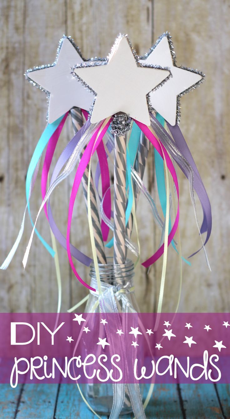 a glass vase filled with paper stars and streamers on top of a wooden table