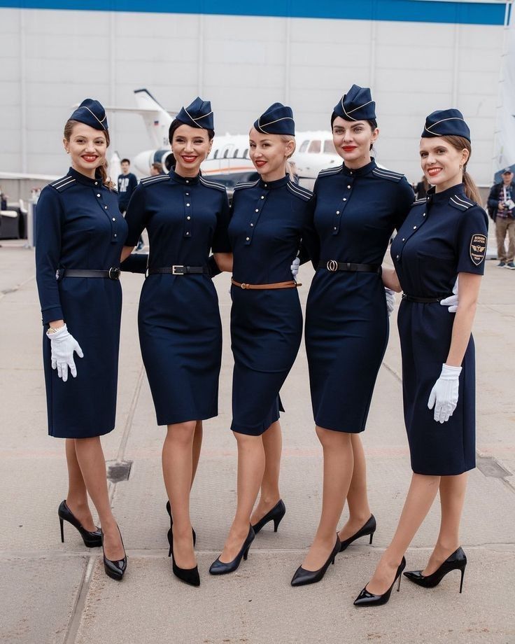 four women in blue uniforms standing next to each other with their hands on their hips