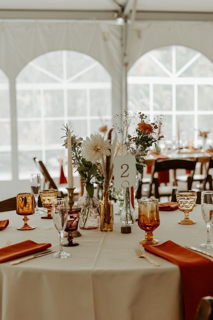 the table is set up with wine glasses and place settings for guests to sit at