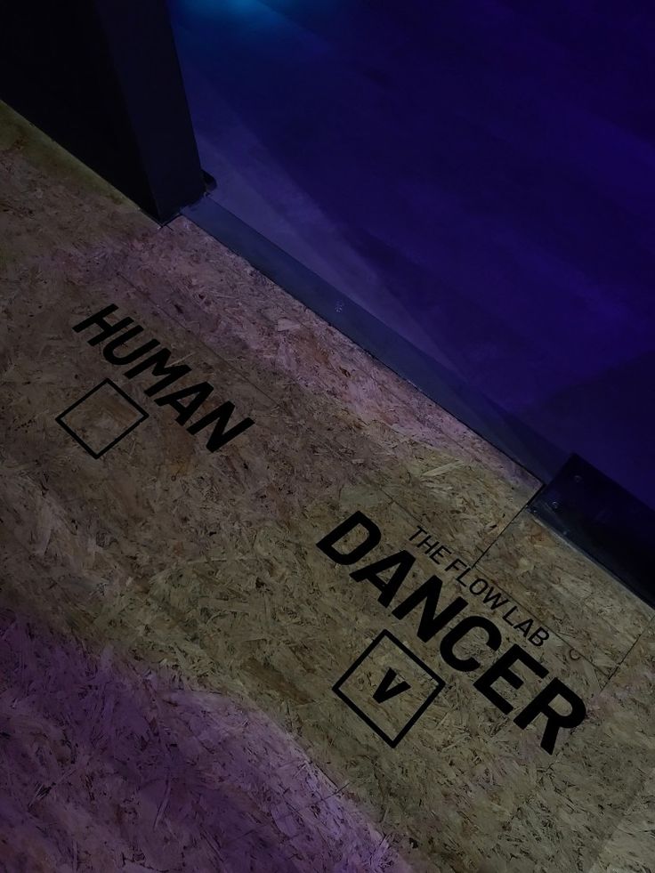 the words human and danger are written in black on a corkboard floor next to an open door