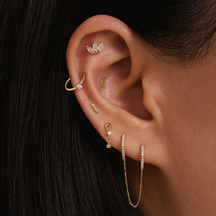 a woman wearing three different ear piercings