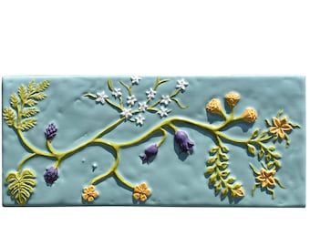 a ceramic tile with flowers and plants on it's side, painted in blue