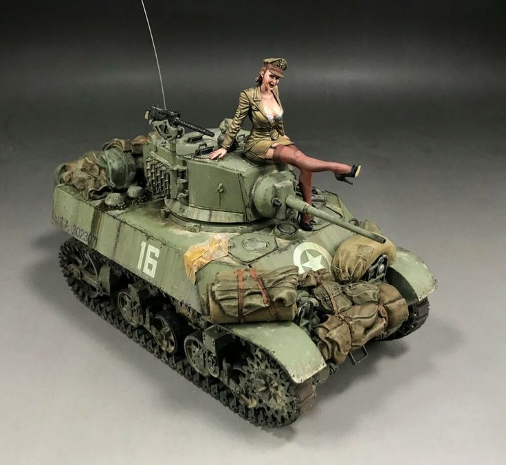 a woman is sitting on top of a tank