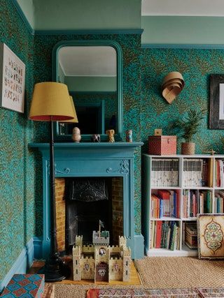 a living room filled with furniture and a fire place next to a book shelf covered in books