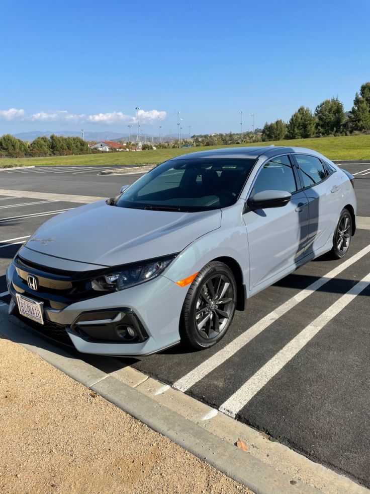 a white car parked in a parking lot next to an empty street with no cars on it