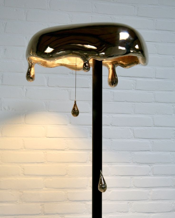 a lamp that is next to a brick wall with water drops hanging from it's sides