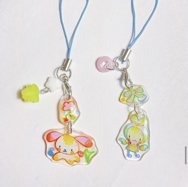 two charms are attached to blue string with an elephant and cat on it's side