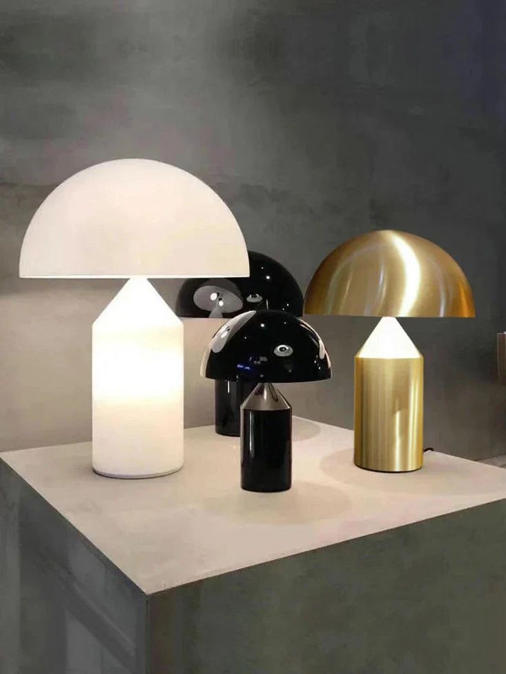 three different types of lamps sitting on top of a white table next to each other