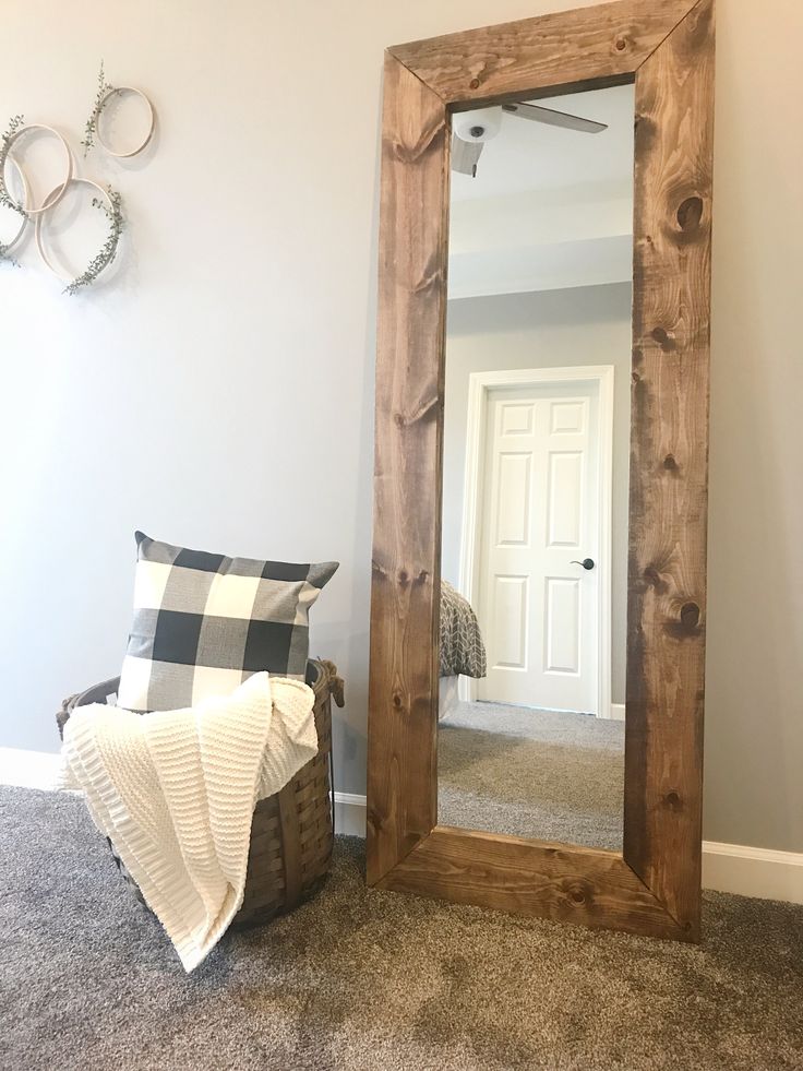 a mirror sitting on the floor next to a chair