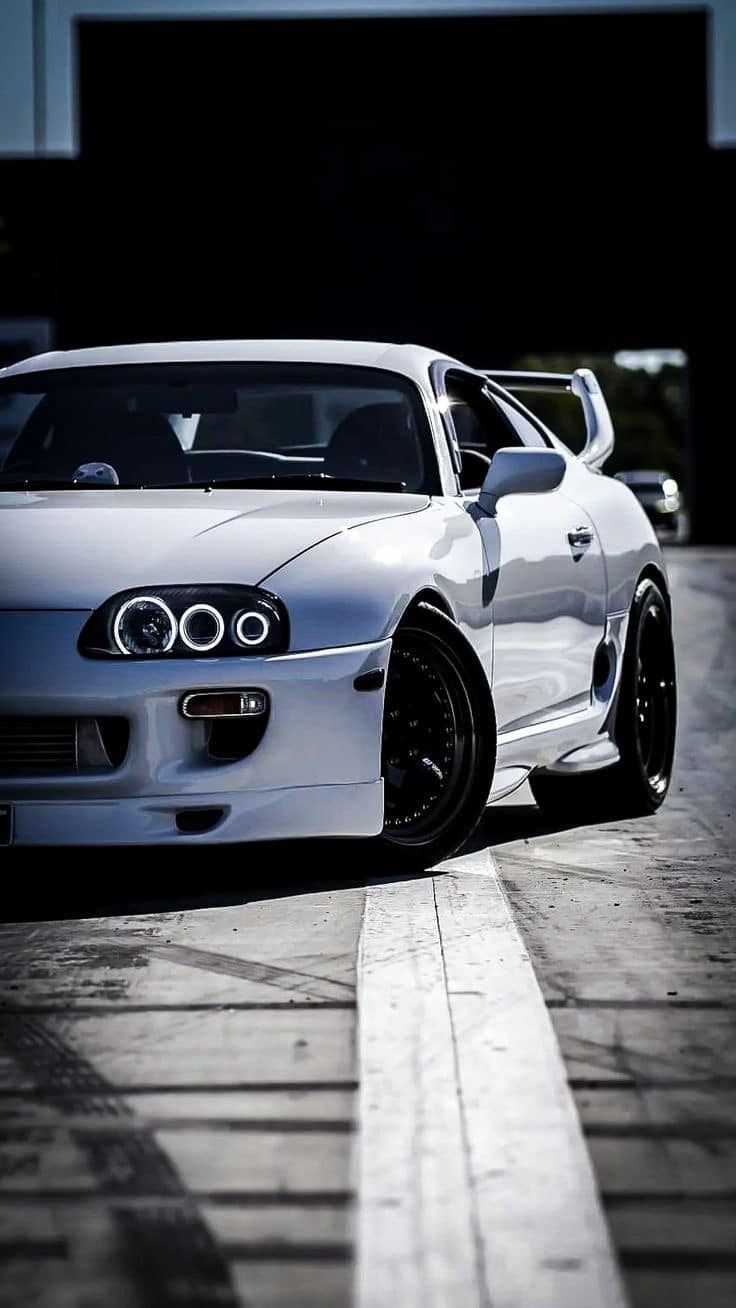 a white sports car parked in front of a building