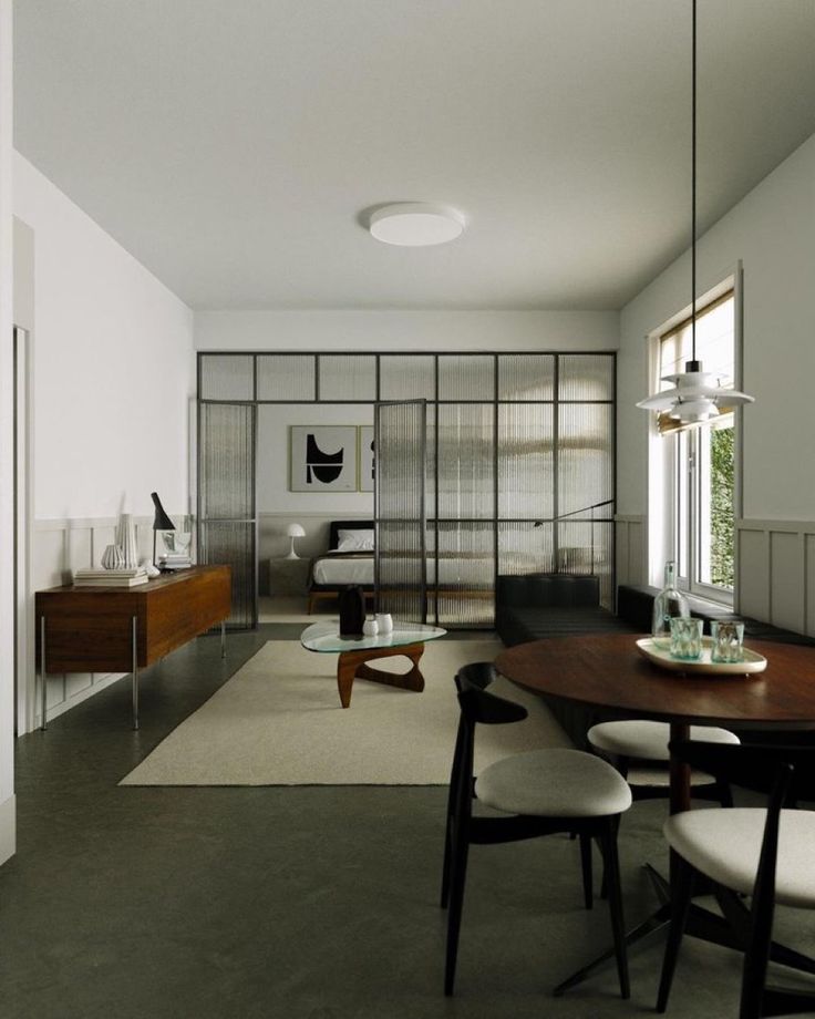 a living room filled with furniture next to a dining table and chairs in front of a sliding glass door