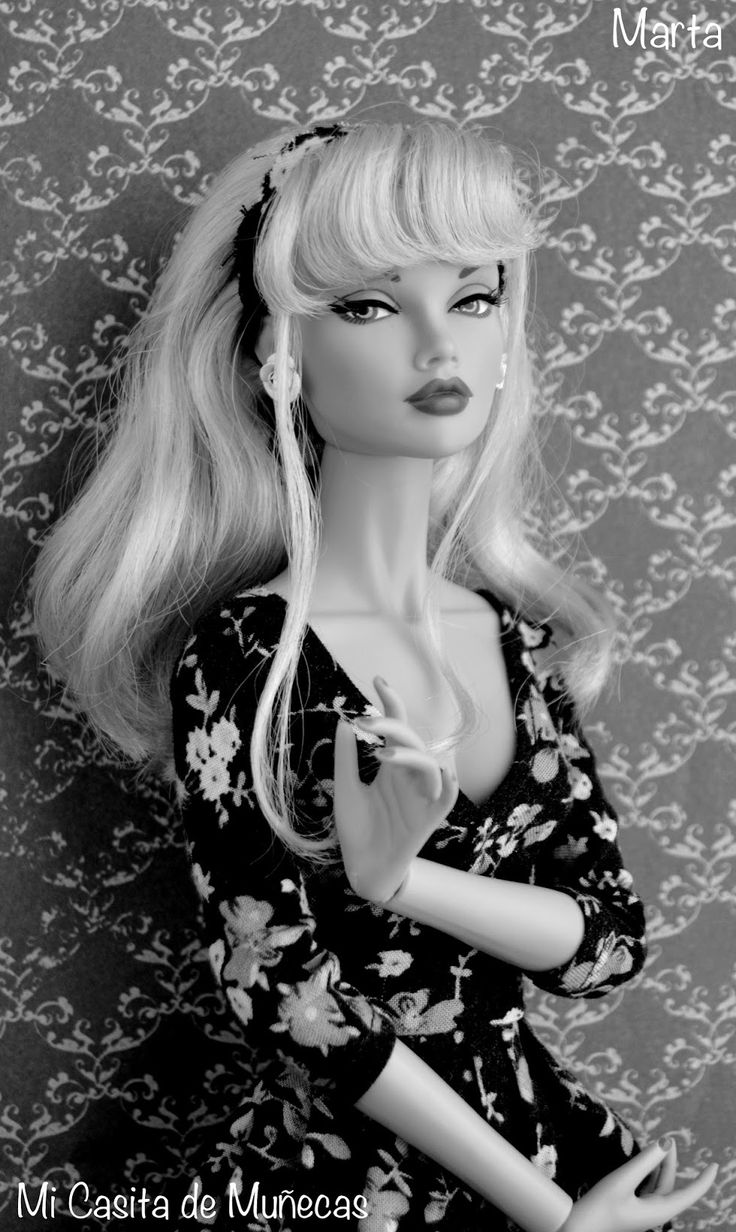 a black and white photo of a barbie doll with long blonde hair wearing a dress