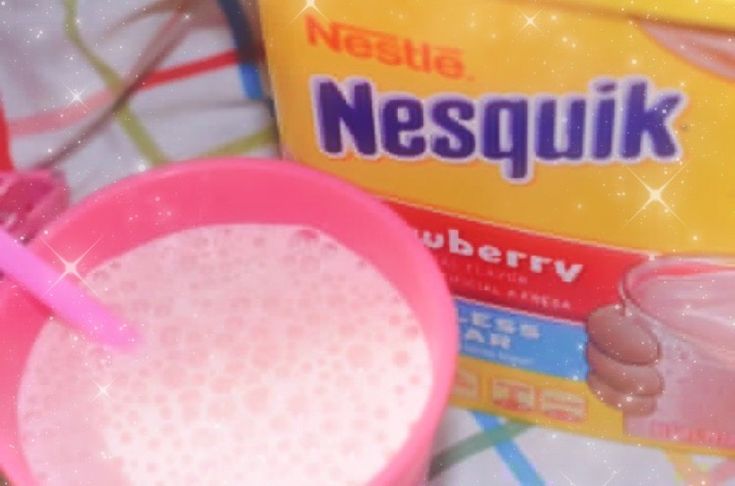 there is a pink cup with a straw in it next to a carton of nepsulk