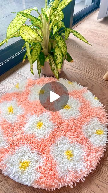 a potted plant sitting on top of a wooden floor next to a round rug