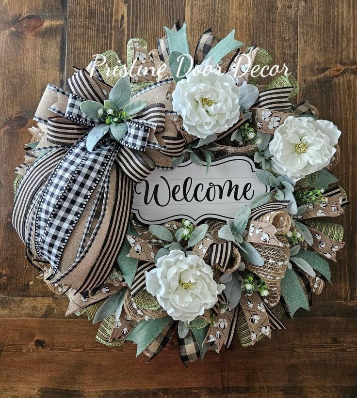 a welcome wreath with white flowers and ribbon