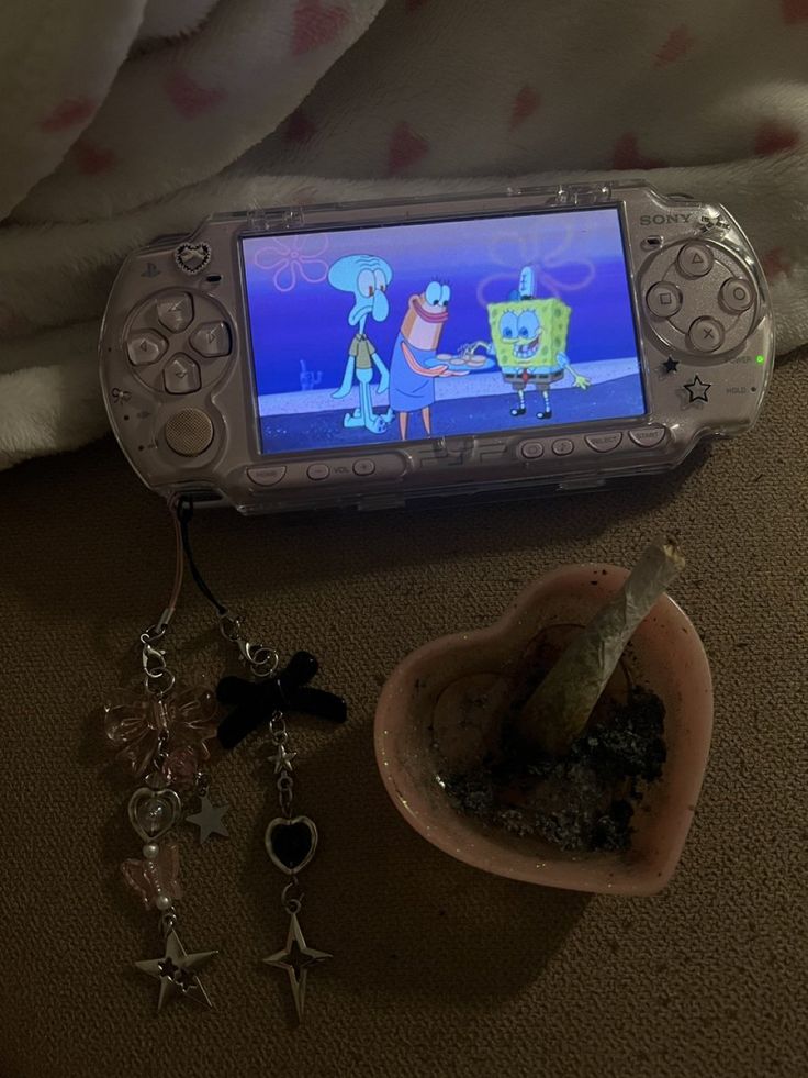 a cell phone sitting on top of a table next to a plant and keychain