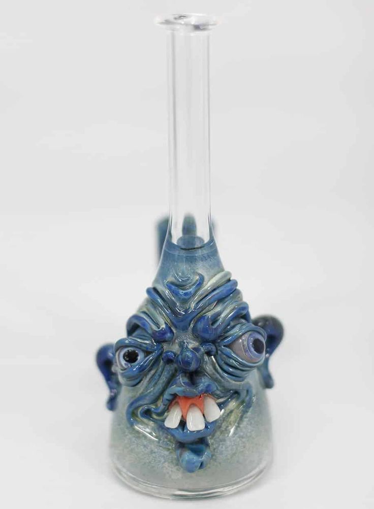 a glass beakle with an evil looking face on it's head and mouth