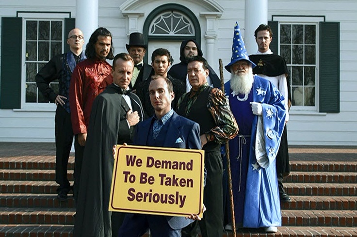 a group of people standing in front of a white building with a sign that says we demand to be taken seriously