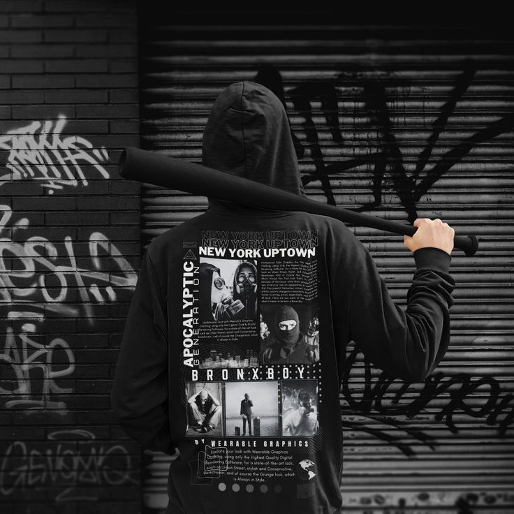 a man with a baseball bat standing in front of a wall covered in grafitti